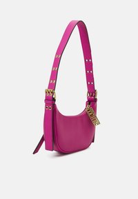 Bright pink leather handbag with gold eyelets on strap and a gold zipper pull featuring "Versace Jeans Couture" text.
