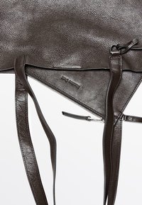 Sac à main en cuir marron foncé texturé avec de longues lanières et une pochette zippée visible portant l'étiquette "Massimo Dutti".
