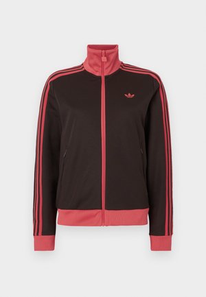 Zwarte sportjas met een hoge kraag, roze accenten, twee steekzakken aan de zijkant en drie roze strepen op elke mouw. Klein logo op de borst.