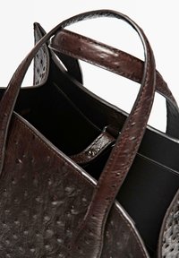 Braune Leder-Shopper-Tasche mit geprägtem Muster, stabilen Griffen und einem offenen Innenraum mit dunklerer Fütterung.