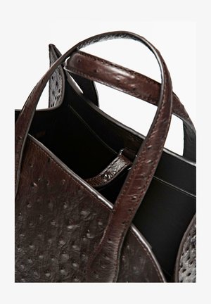 Brązowa skórzana torba typu tote z wytłoczonym wzorem, solidnymi uchwytami i otwartym wnętrzem z ciemniejszą podszewką.