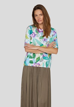 Floral short-sleeve blouse in light blue with green leaves and purple flowers; paired with a pleated, long olive-green skirt.