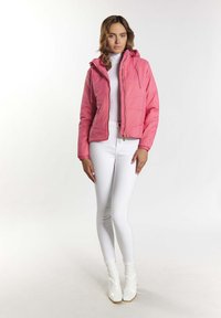 Giacca piumino rosa con cappuccio, chiusura zip e polsini elastici. Abbinata a pantaloni bianchi aderenti e stivali alla caviglia bianchi lucidi.