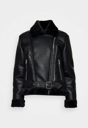 Black leather jacket with a fuzzy collar, zippered side pockets, and a belted waist. Features a smooth texture with contrasting cuffs.