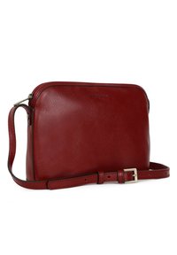 Borsa a tracolla rossa in pelle con una texture liscia, forma rettangolare, chiusura con zip e tracolla regolabile con fibbia in tonalità argentata.