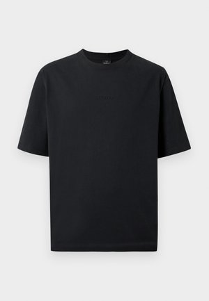 T-shirt in cotone nero con scollatura tonda, maniche corte e taglio dritto. Presenta un logo in rilievo discreto sul davanti.