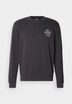 Dark gray sweatshirt featuring a round neck, ribbed cuffs, and hem. Front graphic text reads “BEST FLAVOURS IN TOWN” in multicolor.