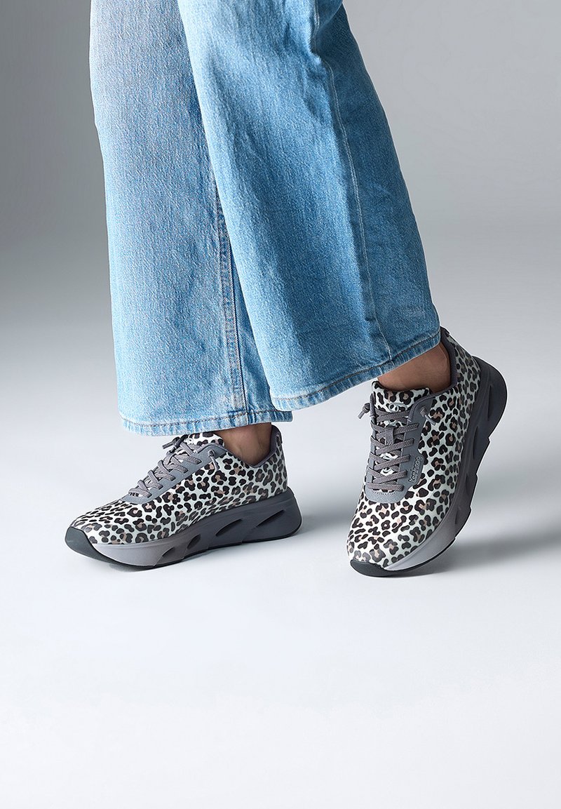 Baskets à imprimé léopard gris et blanc avec un design à lacets, semelle rembourrée et bout rond, associées à un jean large bleu clair.