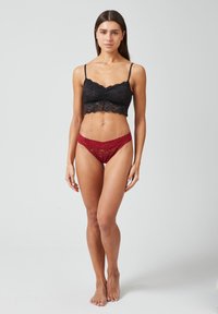 Zwart kant bralette met dunne bandjes en golvende randen, gecombineerd met bordeauxrode kanten slipjes met bloemmotieven en een lage taille.
