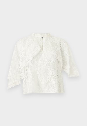 Witte bloemen kanten blouse met doorzichtige stof, vlindermouwen, een hoge halslijn en gezoomde randen aan mouwen en zoom.