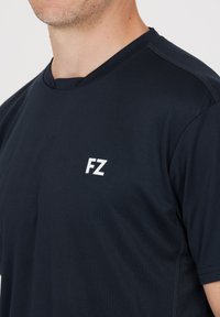 Mörkblå kortärmad tränings t-shirt med rundhals, vit "FZ" logotyp på vänster bröst, tillverkad av lätt och texturerad tyg.