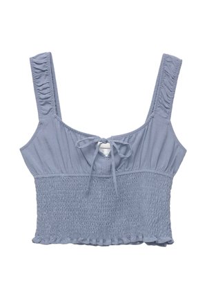 Blå cropped topp med tjocka axelband, med smockad textur och en framknutningsdetalj. Volangkant i botten. Tillverkad av bomullsblandning.