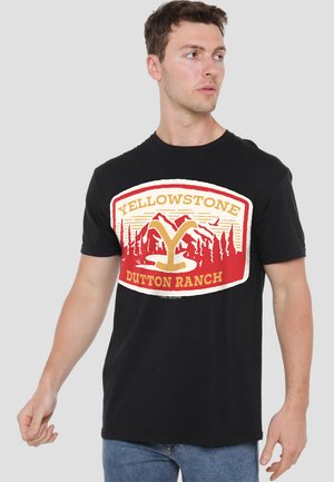 Black cotton T-shirt featuring a red and gold graphic design with "YELLOWSTONE DUTTON RANCH" text and mountain imagery. Short sleeves.