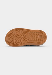 Σόλα παπουτσιού Adidas από ταμπα λάστιχο με κυκλικά και γεωμετρικά μοτίβα πέλματος και λογότυπο Adidas κοντά στο κέντρο.
