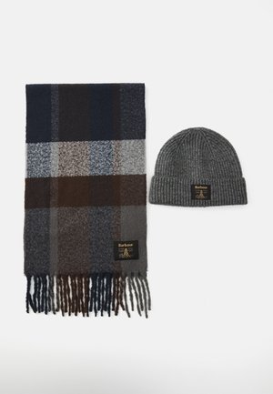 Wool plaid scarf in navy, brown, and gray with fringes, next to a gray ribbed knit beanie, both labeled Barbour.