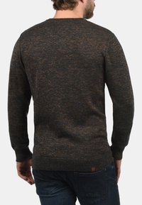 Strickpullover in Dunkelgrau mit braunen Sprenkeln, runder Ausschnitt, gerippte Ärmelbündchen und Saum. Verfügt über ein kleines Leder-Logoetikett an der unteren Seite.