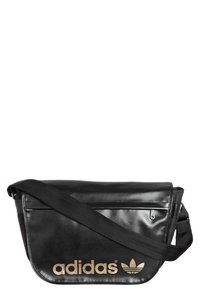 Svart messenger-väska i faux läder med en lång rem, som har en guldig "adidas"-logotyp och trefoil-design, ficka med dragkedja och slät textur.