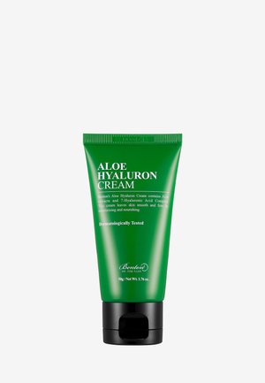 Grön plasttub med svart lock, märkt "Aloe Hyaluronkräm." Texten innehåller produktinformation; den eleganta cylindriska formen betonar funktionaliteten.