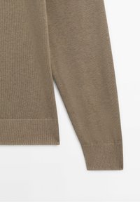Brauner gerippter Strickpullover mit strukturierter Oberfläche, Rundhalsausschnitt und langen Ärmeln. Der Saum hat einen kontrastierenden gerippten Rand.