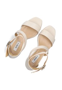 Beige open-toe sandalen met brede banden, vierkante neusontwerp en enkelgesp. Gladde textuur met een platte hak, gelabeld "NOTRE-V."