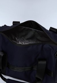 Marinblå duffelväska med dragkedja upptill, svart innerfoder och svarta remmar, med en nätficka inuti för organisering.