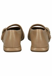 Zapatos de cuero color tostado con un tacón bajo, que presentan una parte trasera redondeada, acentos de hebilla lateral y una textura suave.
