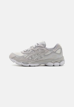 Chaussure de course ASICS gris clair avec des panneaux en mesh et en daim, laçage à l’avant, et une semelle blanche segmentée, vue de côté extérieur.
