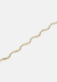 Pulsera de tono dorado con eslabones ondulados, textura suave y acabado brillante. El diseño elegante presenta curvas alternas y conexiones.