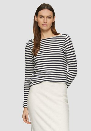 T-shirt à manches longues rayé en marine et crème, avec un décolleté bateau et une coupe décontractée. Associé à une jupe de couleur claire.