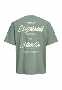 Πράσινο T-shirt με κοντά μανίκια και λευκό τυπωμένο κείμενο με την επιγραφή Originals Studio και επιπλέον δημιουργικές φράσεις στο πίσω μέρος.