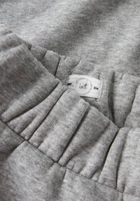 Grijze elastische tailleband met een verstelbare knop en stoffen lussje op zachte sweatshirtstof.