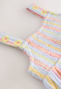 Abito texturizzato di colore azzurro chiaro con strisce rosa, gialle e verdi. Presenta spalline ricamate con motivi floreali e dettagli arricciati.