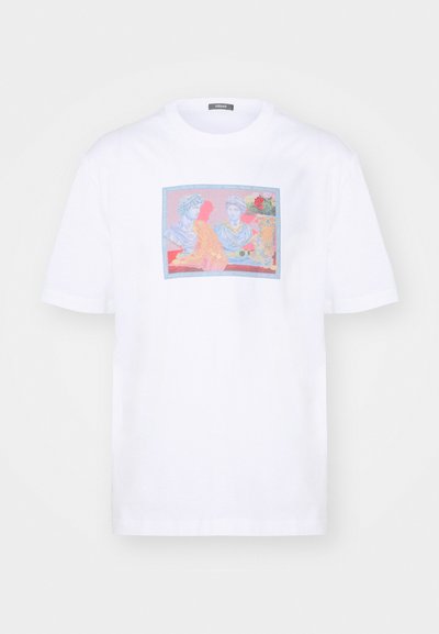 Camiseta de algodón blanca con un gráfico colorido que presenta figuras y un león sobre un fondo rosa y azul en un marco rectangular.