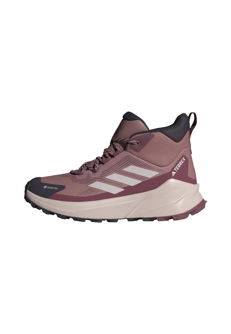 GORE-TEX žygio batai mauve ir pilkos spalvos. Aukštas dizainas su tekstūruota viršutine dalimi, baltais akcentais ir tvirtu padu traukai.