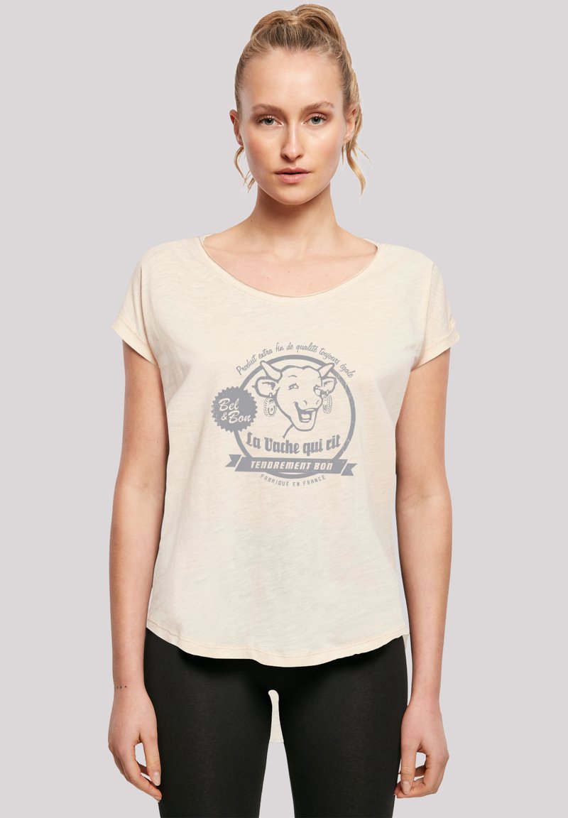 Light beige t-shirt with short sleeves, featuring a printed graphic of a cow, text in blue, and a rounded neckline.