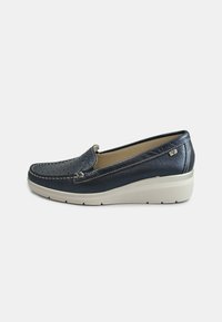 Scarpe slip-on in pelle blu navy con tomaia testurizzata, dettagli cuciti e suola a cuneo di colore crema per un'altezza e comfort aggiuntivi.