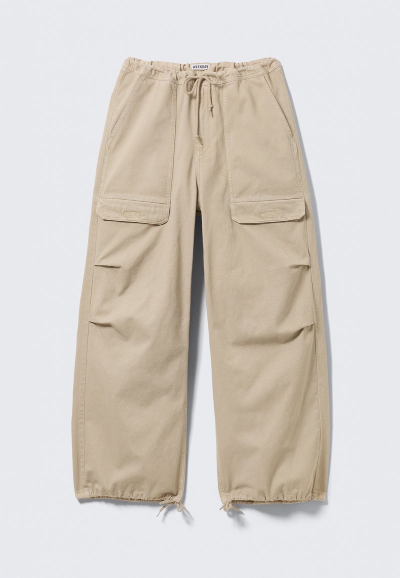 Pantalon cargo large beige avec taille et ourlets à cordon de serrage, poches à rabat sur les cuisses et poches fendues latérales.