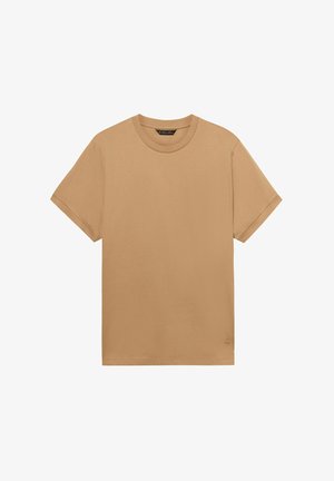 Maglietta semplice di cotone color marrone chiaro, a maniche corte, con collo a girocollo e un piccolo logo ricamato vicino all'orlo inferiore.