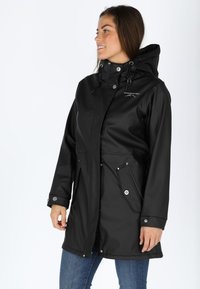 Svart vattentät jacka med huva, framsida med dragkedja, tryckknappar, dragsko och två sidofickor; slät textur, medellång design.