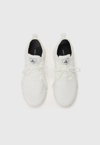 Zapatillas deportivas blancas con parte superior de malla, punta redonda y cordones planos. Presentan un logo en la lengüeta y una lengüeta en el talón.