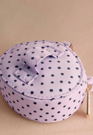 E ovalförmige Tasche aus lavendelfarbenem Stoff mit schwarzen Punkten. Oben verfügt sie über einen Klettverschluss und einen goldfarbenen Reißverschluss-Zipper an der Seite.