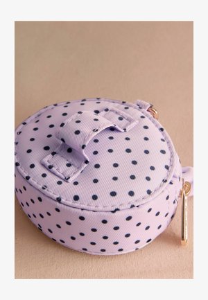 Apskritas maišelis levandų spalvos grubio audinio su juodomis taškeliais. Viršus turi lipnų uždarymą ir auksinės spalvos užtrauktuko viršūnėlę šone.