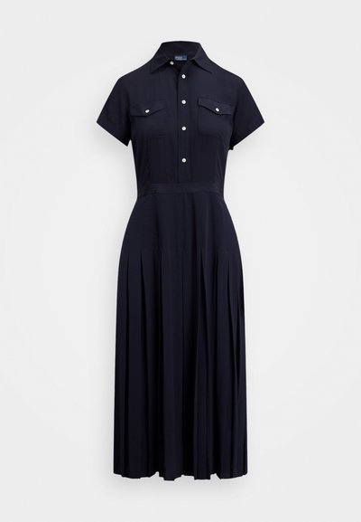Mornarsko modra srajčna obleka s kratkimi rokavi, gumbi spredaj, žepi na prsih, oprijet pas in plisirana midi krila.