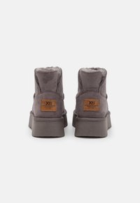 Botas de tobillo de ante gris con forro de piel sintética, cuello acolchado y suela de goma texturizada. Presenta un parche de piel de la marca en el talón.