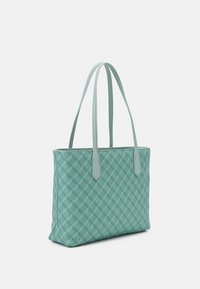 Mintgrön tote-väska med en strukturerad diamantmönster, med två långa handtag och en platt botten, tillverkad av syntetiskt material.