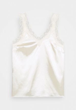 Haut cami en satin crème avec une dentelle le long de l'encolure et des bretelles, présentant une texture lisse et un design simple.