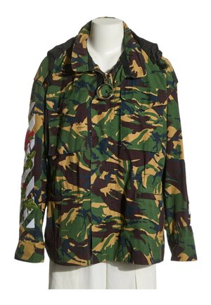 Veste style militaire avec motif camouflage vert, marron et beige, poches avant et broderie florale sur la manche gauche.