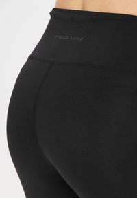Svarta högmidjade leggings tillverkade av stretchigt material. Har kontrasterande sömmar och en diskret "ENDURANCE"-logotyp på midjebandet.