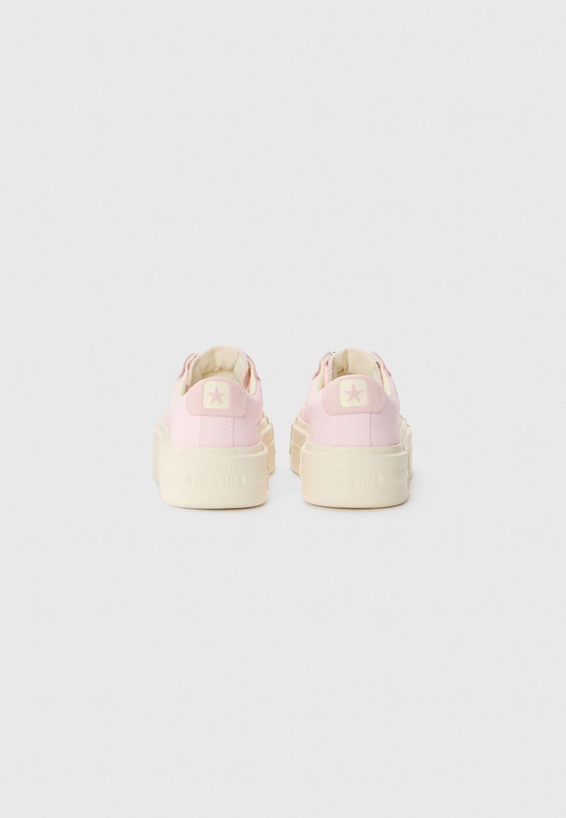Rosa Leinenschuhe mit weißen Gummisohlen, kreisförmigem Logo an der Ferse und kontrastierenden Nähten. Verfügt über ein niedrig geschnittenes Design und eine strukturierte Oberfläche.