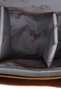 De binnenkant van de bruine leren tas heeft een soepele grijze voering met bruine waterdichte prints en meerdere compartimenten voor organisatie.